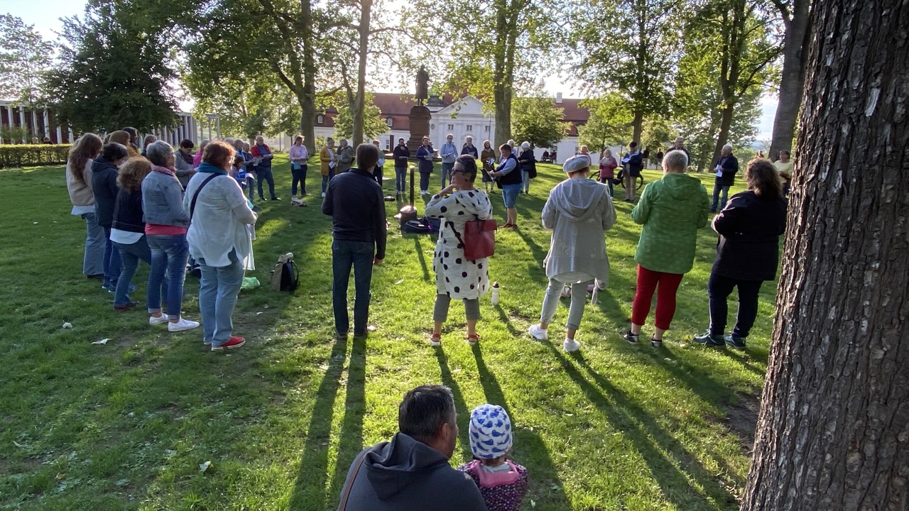 Menschen singen gemeinsam bei Sonnenuntergang